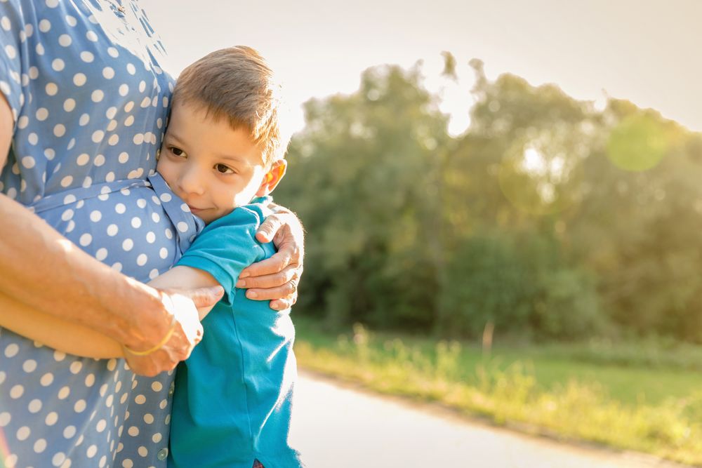 Happy grandson hugging his grandmother outdoors