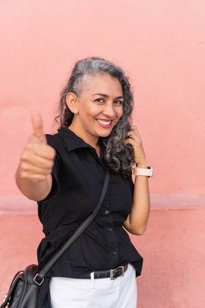 Older gray-haired woman laughing while looking at the camera.