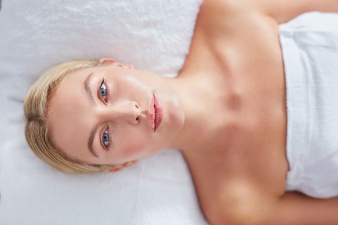 Blonde woman lying back and relaxing after treatment looking up