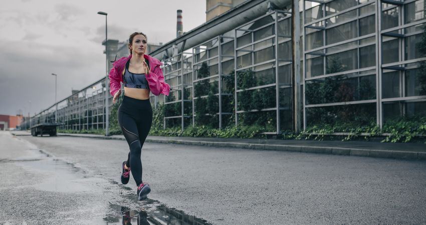 Sportswoman running in an industrial zone