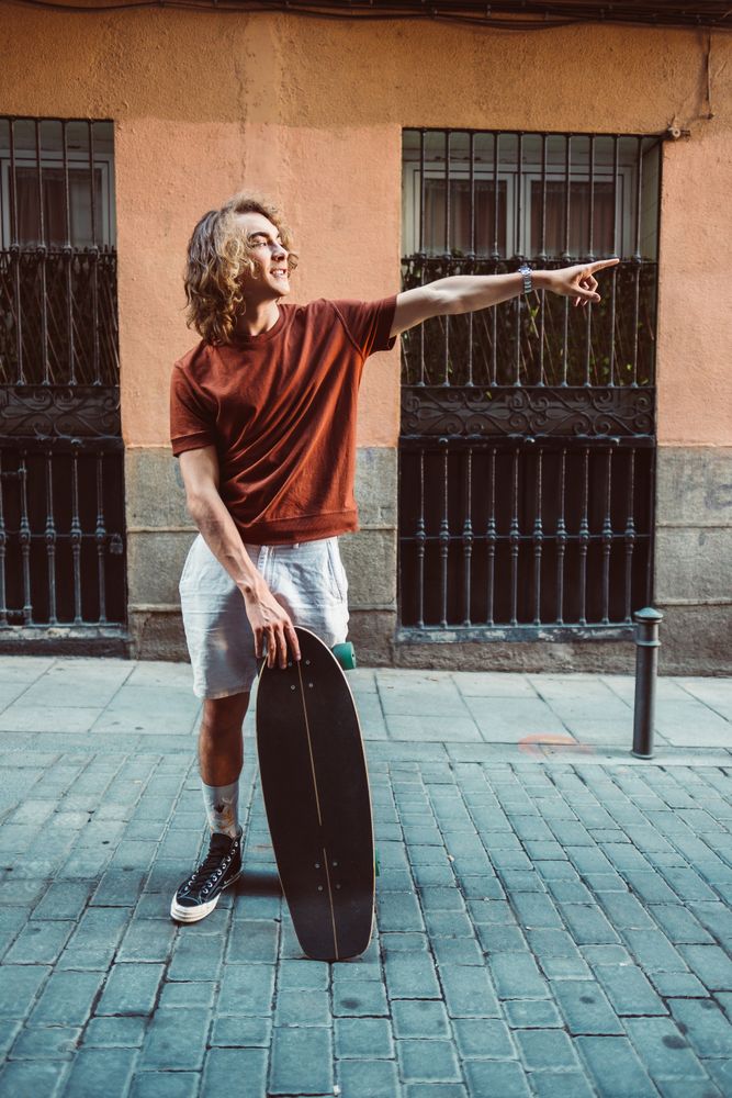 Man carrying longboard on the street