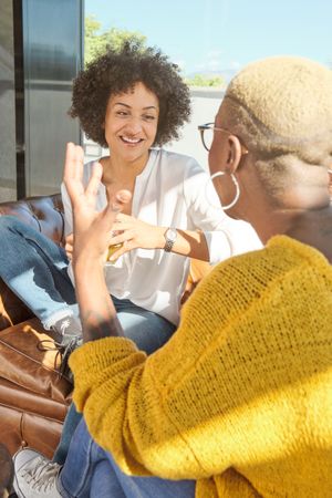 Happy friends talking near window during weekend
