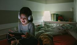 Girl with headphones looking at the tablet