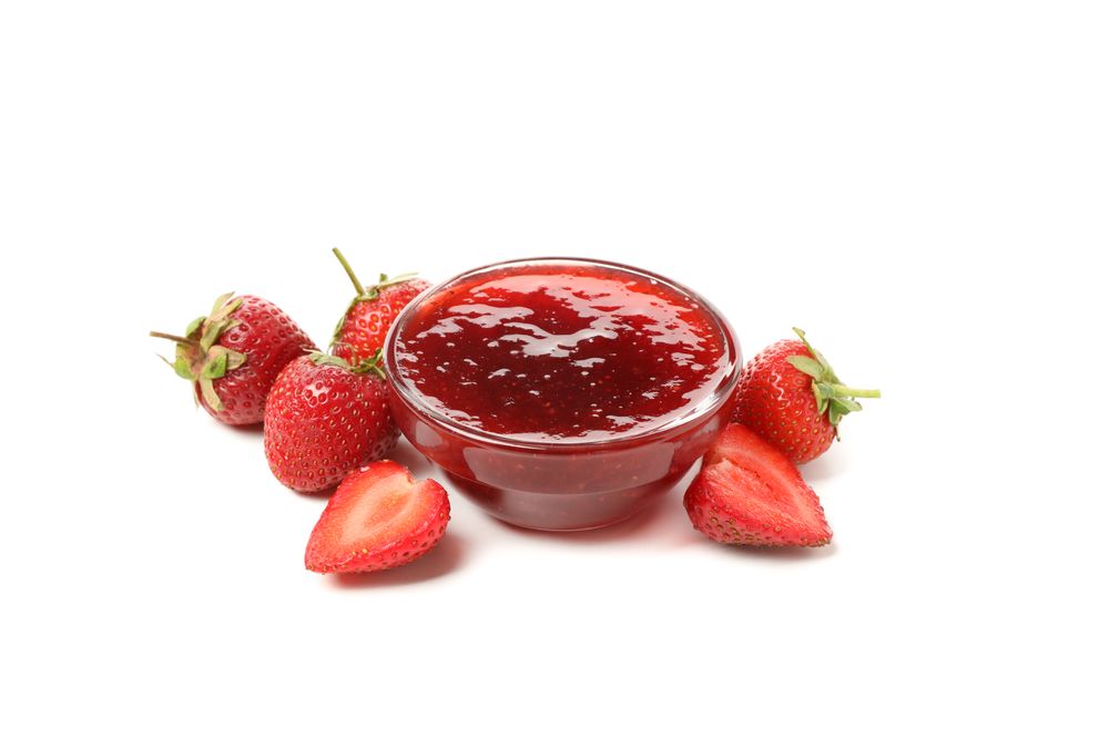 Strawberry and bowl with jam isolated on plain background