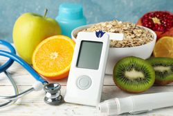 Blood glucose meter and diabetic food on wooden table