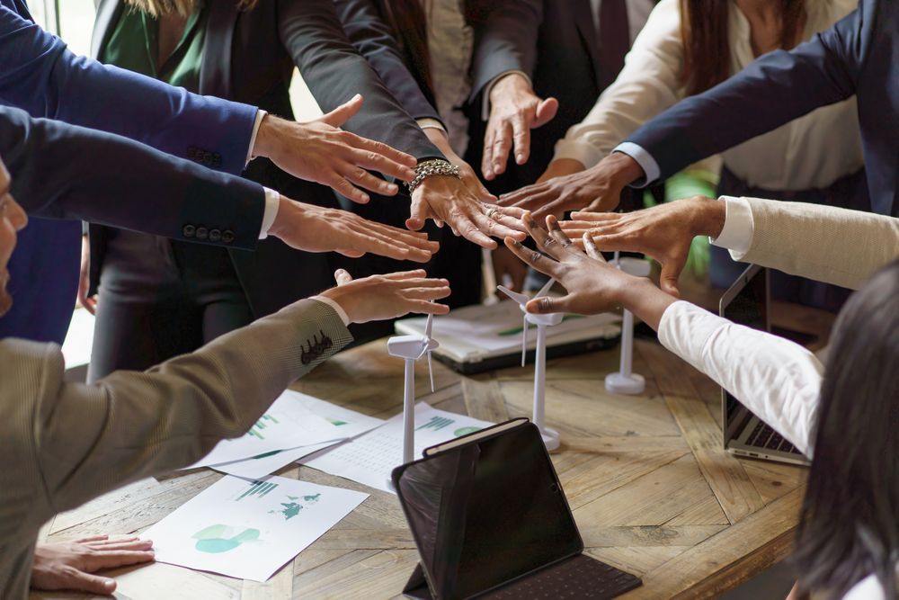 Diverse team in a putting their hands together over a table after meeting