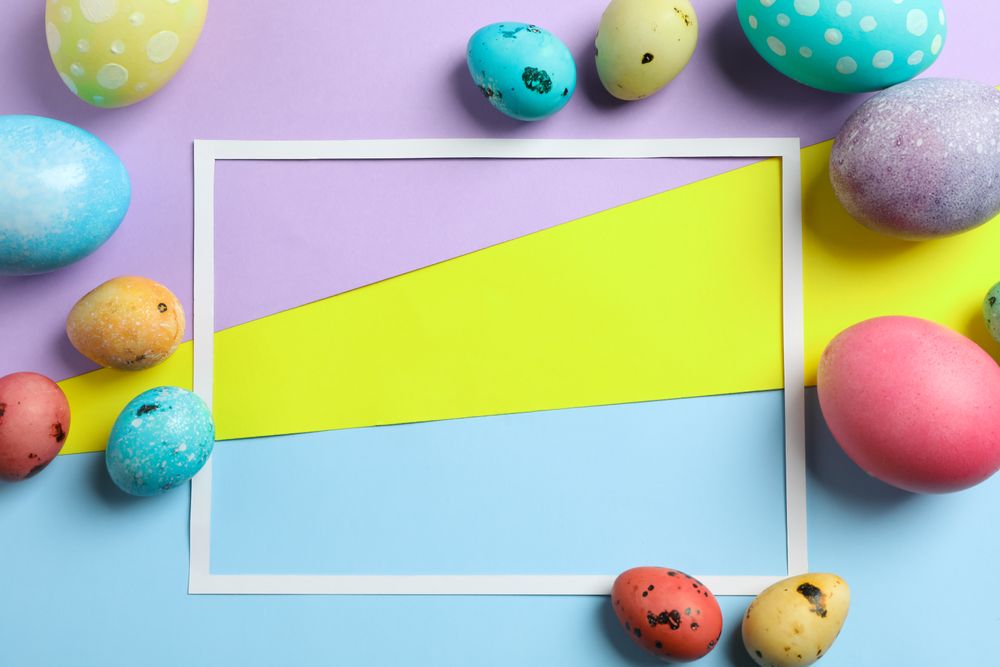 Decorated easter eggs on colorful background with frame empty for text. Festive tradition. Space for text. Top view