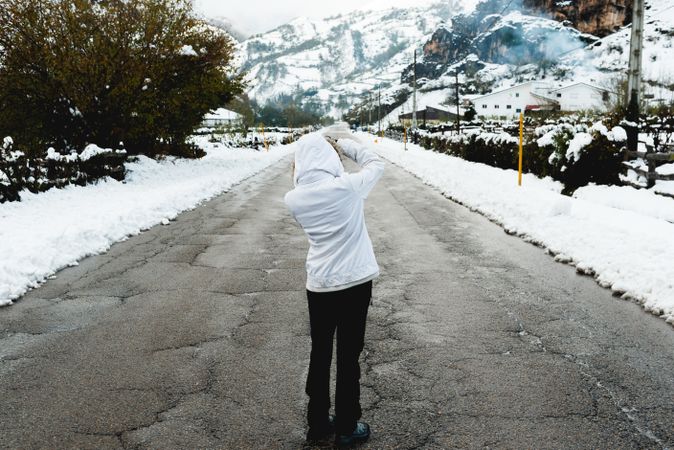 Anonymous person standing on road in countryside