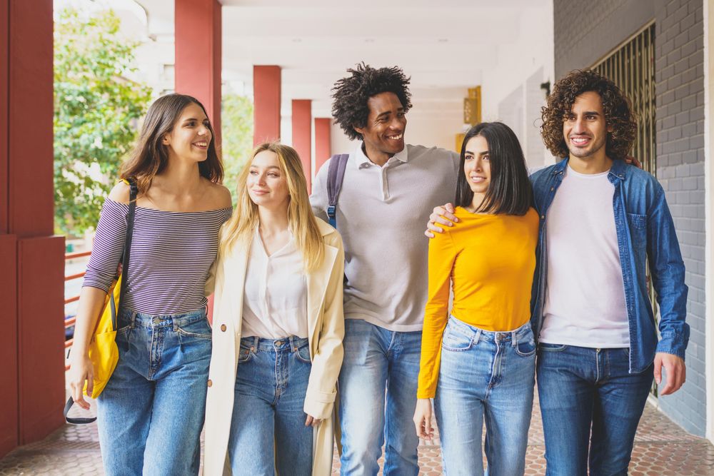 Smiling group of friends walking down street outside