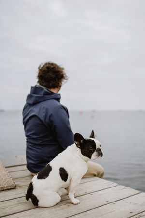Man and dog resting on pier together