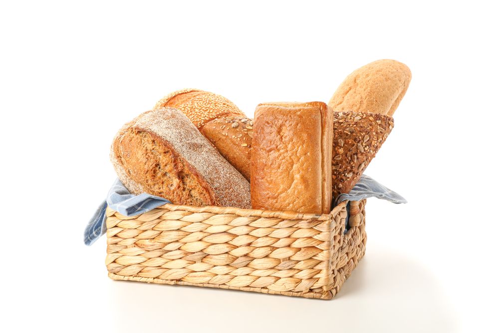 Bakery products in straw basket isolated on blank background