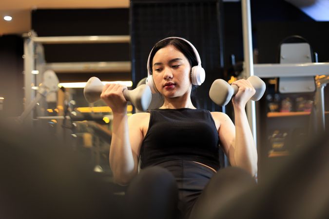 Young Female Training at the Gym Using Dumbbells