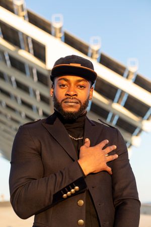 Portrait of stylish Black man standing outdoors in front of modern structure