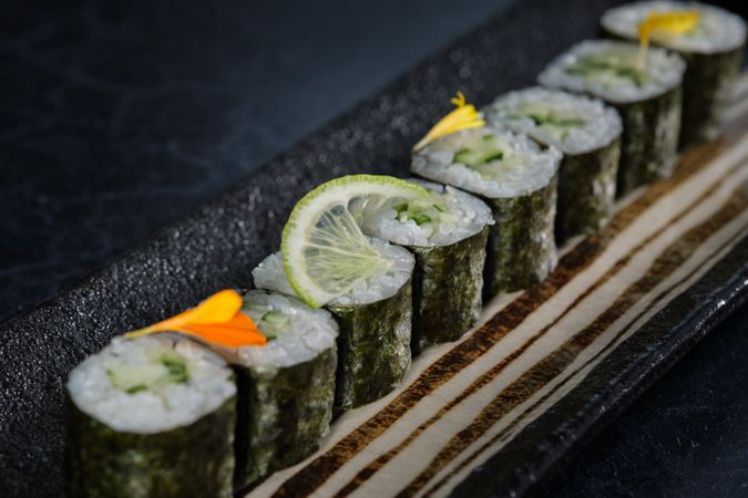 Fresh sushi rolls with lime slice and flower