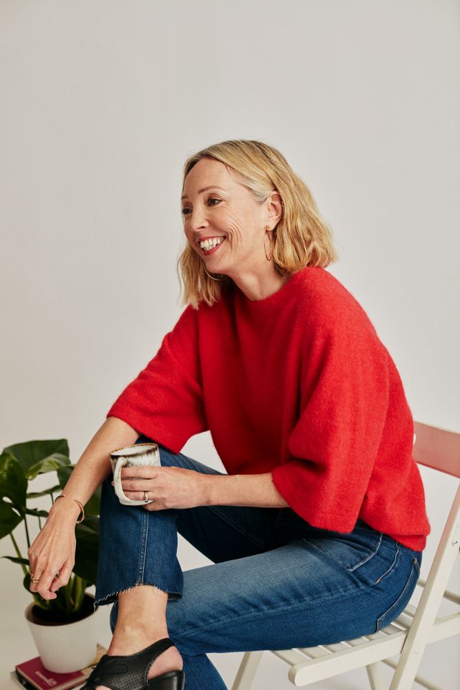 Woman in red jumper on chair and smiling