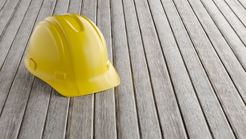 Yellow Hard Hat on a Wood Background with Room for Text.