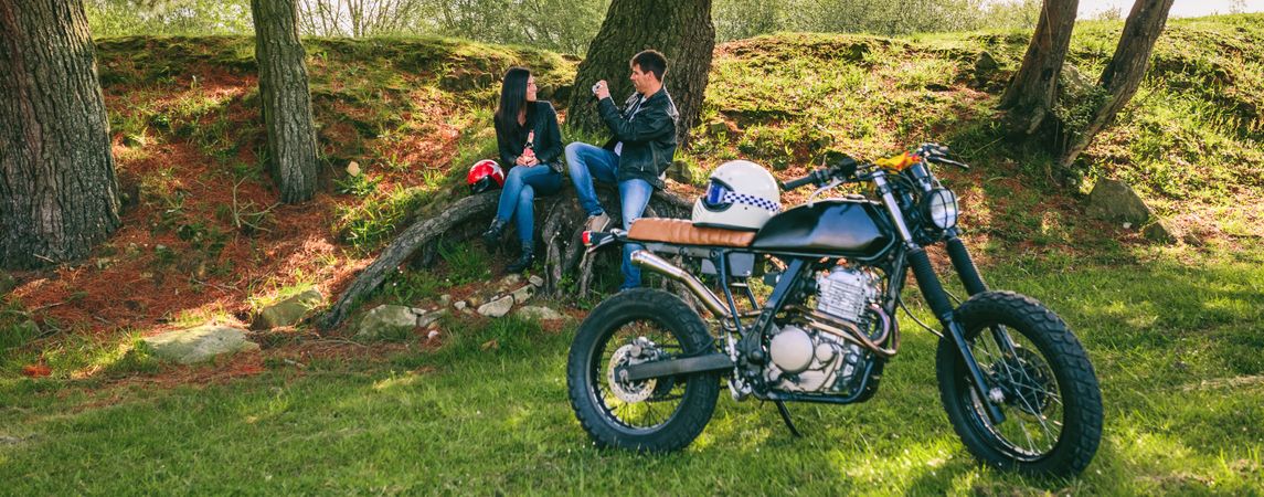 Couple resting from a motorcycle trip taking picture