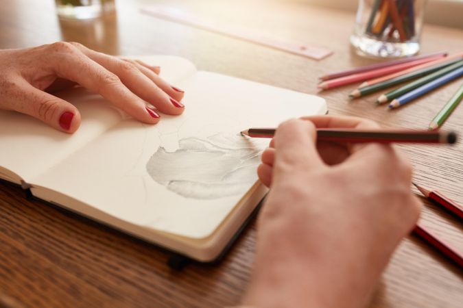 Close up image of woman hands sketching flower on a sketchbook
