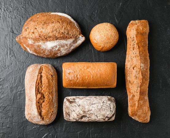 Flat lay composition with bakery products on dark background, top view