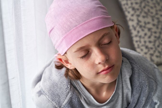 Little boy with closed eyes in pink bandana