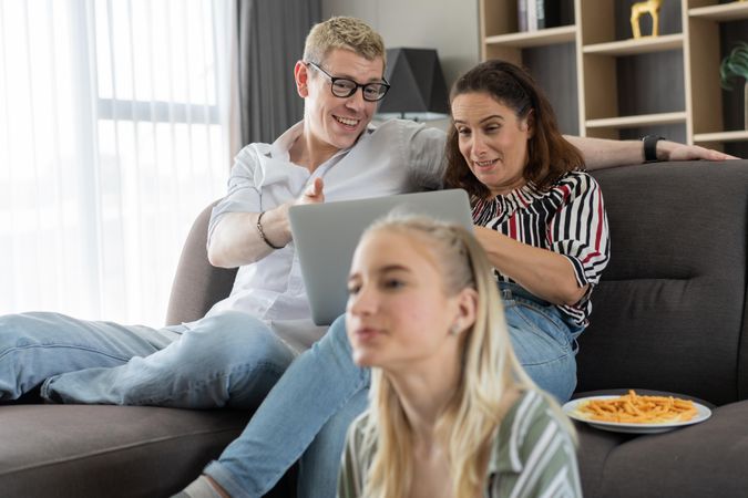 Man watching movie with his wife with daughter sitting on floor