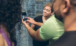 Athletes looking at the mobile of a gym mate