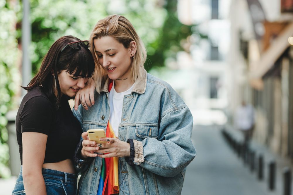Lesbian couple on the mobile phone on street
