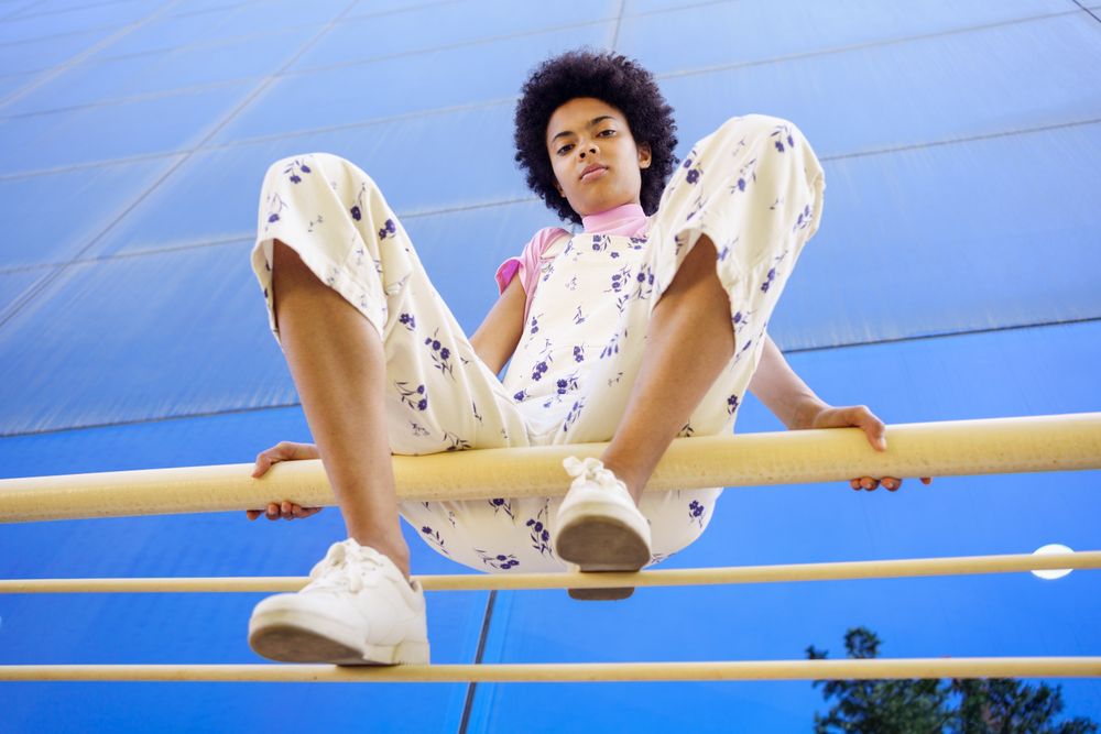 Low angle shot of serious woman sitting on handrails in front of  reflective office building