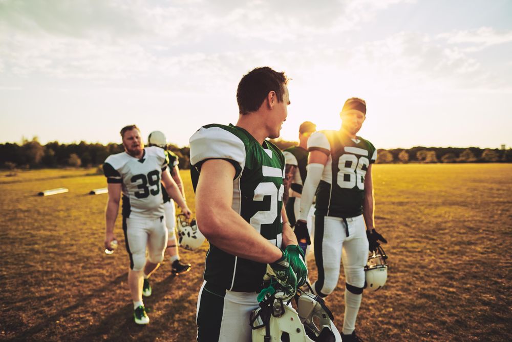 Group of footballers walking off the field together after a game