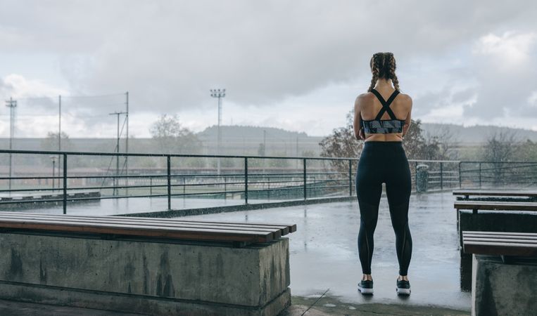 Sportswoman posing backwards watching the rain
