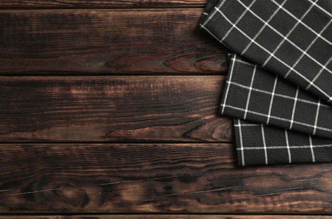 Fabric napkins on wooden background, space for text
