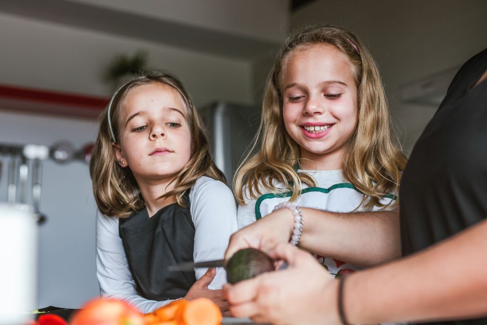 Anonymous adult preparing vegetables for salad with kids