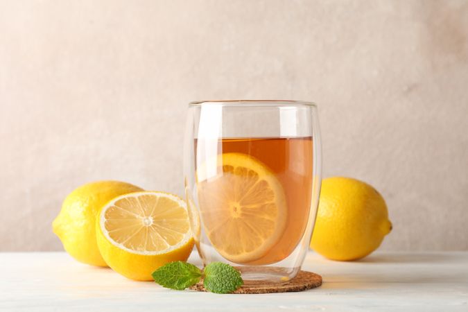 Glass of tea with lemon, mint, honey, dipper and ginger on wooden background ,copy space