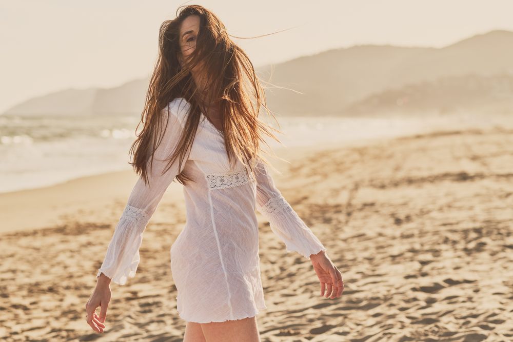 Young woman at the beach at sunset
