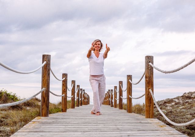 Cheerful woman exercising on timber path