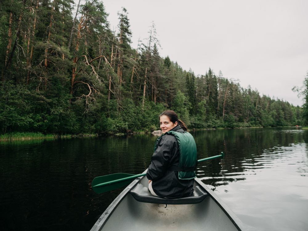 Woman boating on forest river in Finland