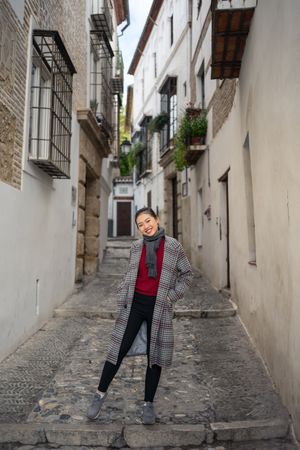 Joyful female tourist in casual wear amid city street