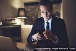 Businessman in suit texting at night 42NPe4