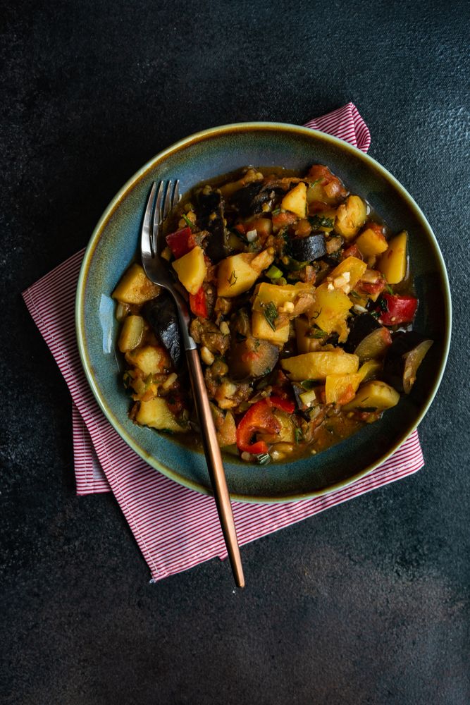 Top view of Georgian summer and autumnal dish Ajapsandali with vegetables on stone background with copy space