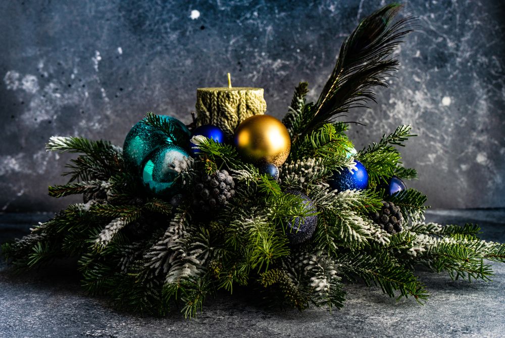 Side view of Christmas festive centerpiece with candle and pine arrangement