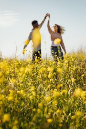 Romantic couple dancing in meadow of yellow flowers