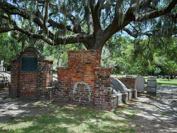 Red brick cemetery graves with Spanish moss draped overhead