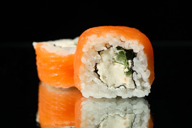 Delicious sushi rolls on dark mirror background. Japanese food