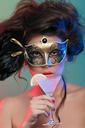 Woman in mask holding glass of drink