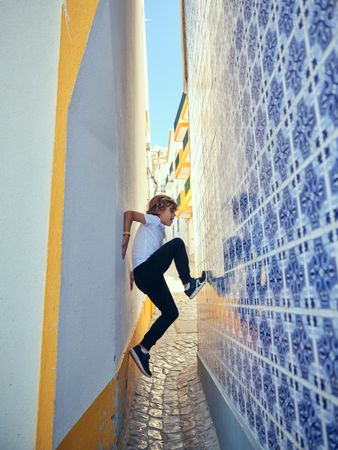 Energetic boy trying to scramble on wall