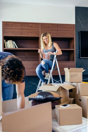 Couple unpacking boxes and placing books