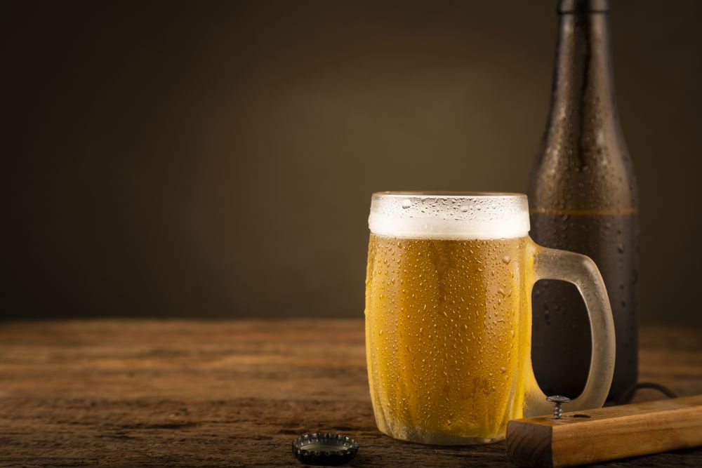 Glass full of cold beer on the wooden table