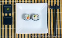 Top view of sushi maki rolls presented on a plate with sauces and chopsticks bxZnr5