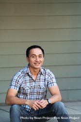 Portrait of man sitting on porch smiling and looking at camera 4261q4
