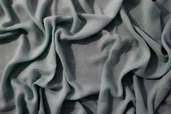 Nude green fabric wavy crumpled background texture with copy space.